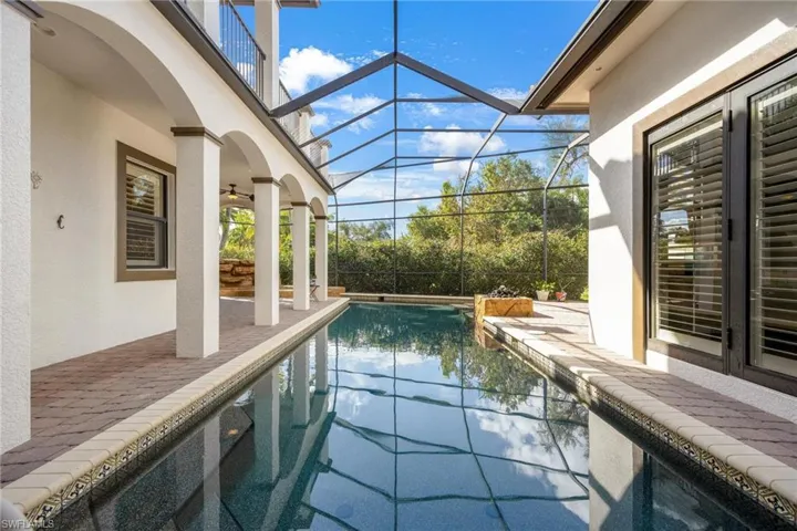 View of swimming pool with a patio area, ceiling fan, and a lanai