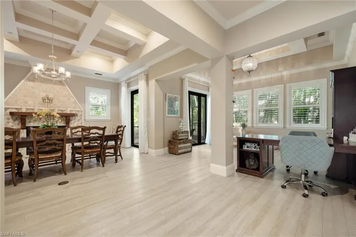 Office space featuring coffered ceiling, an inviting chandelier, crown molding, beamed ceiling, and light hardwood / wood-style floors
