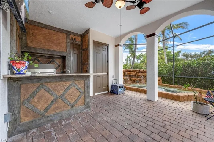 View of patio / terrace featuring ceiling fan, a lanai, and an outdoor kitchen