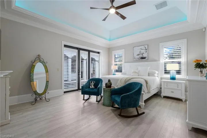 Bedroom with access to outside, a raised ceiling, crown molding, ceiling fan, and light hardwood / wood-style floors