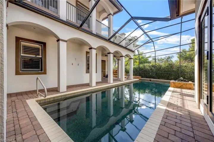 View of pool with a patio and glass enclosure