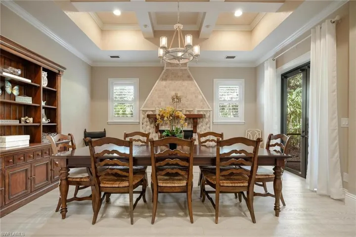 Dining room featuring beam ceiling, an inviting chandelier, coffered ceiling, and ornamental molding