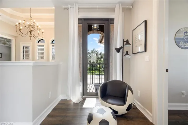 Entrance foyer with a chandelier, crown molding, and dark wood-type flooring