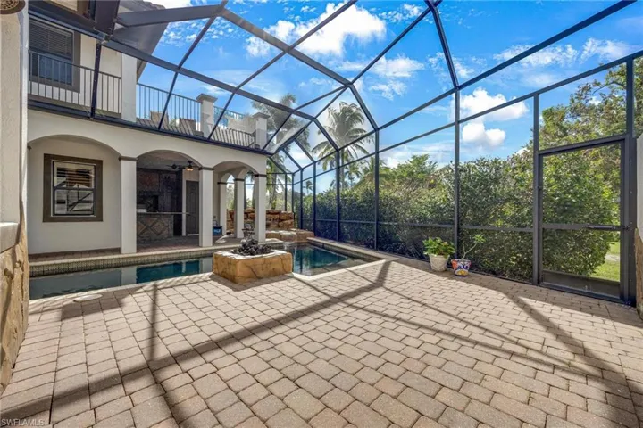 View of pool with a patio and glass enclosure