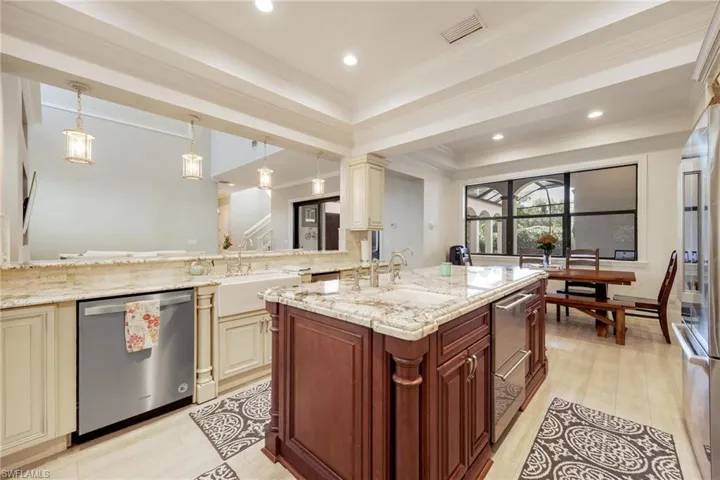 Kitchen with cream cabinets, stainless steel dishwasher, decorative light fixtures, and ornamental molding