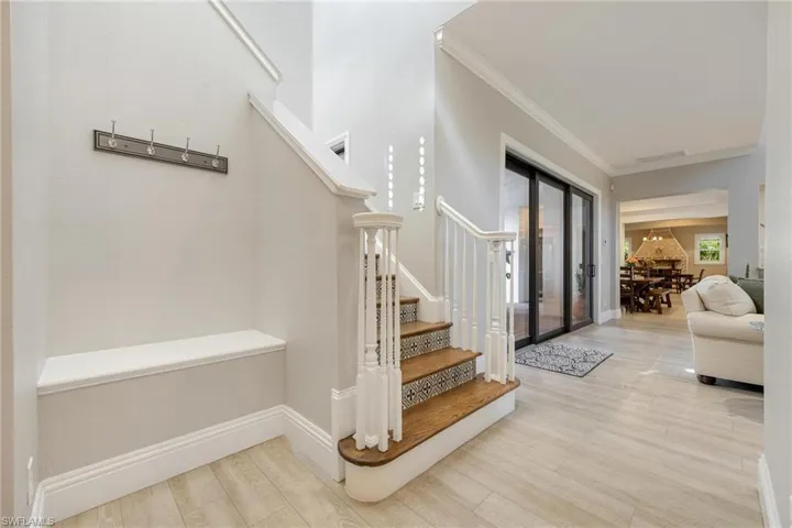 Stairs featuring hardwood / wood-style flooring and ornamental molding