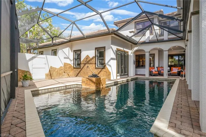 View of swimming pool with outdoor lounge area, a lanai, and a patio