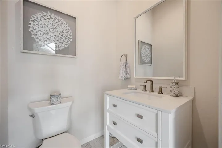 Bathroom featuring hardwood / wood-style flooring, vanity, and toilet