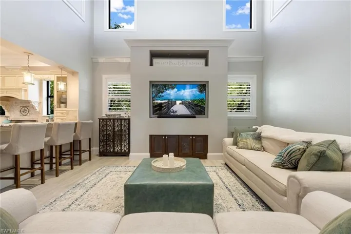 Living room featuring plenty of natural light, light hardwood / wood-style floors, and a high ceiling