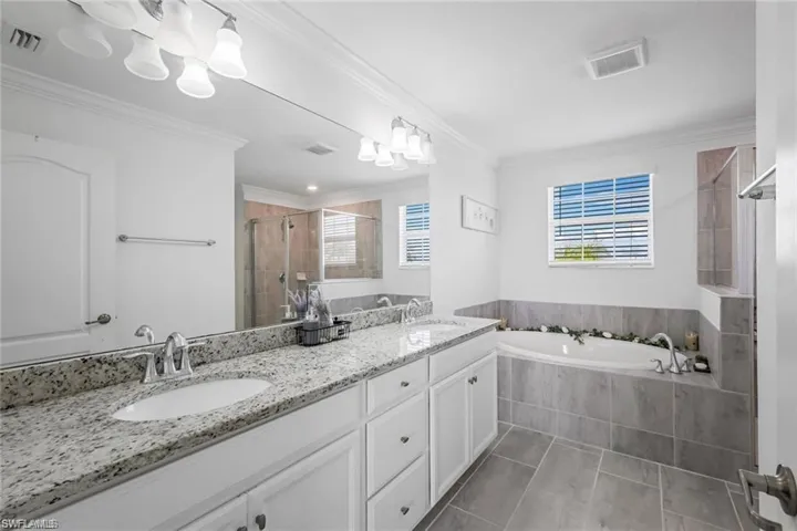 Full bath with visible vents, a stall shower, and a sink