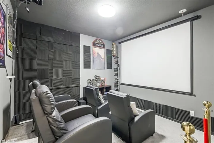 Home theater room with carpet floors and a textured ceiling