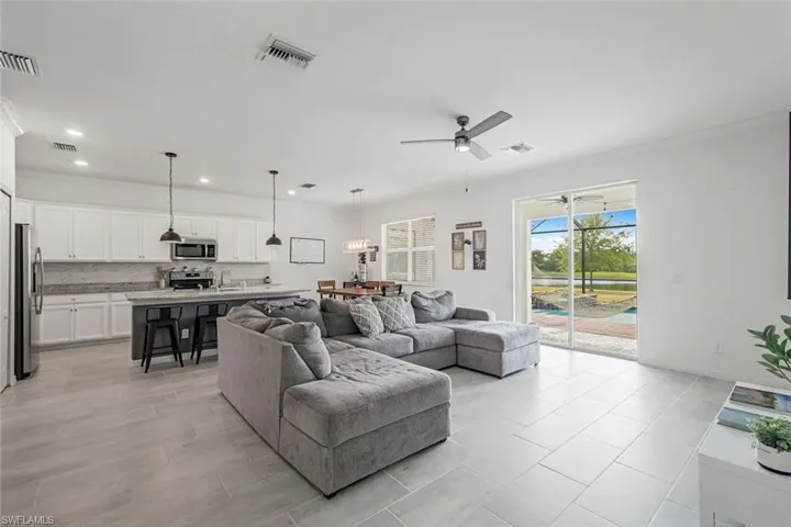 Living area with a ceiling fan, visible vents, and recessed lighting