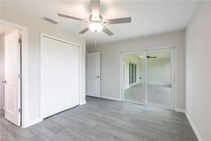 Unfurnished bedroom featuring wood finished floors, a closet, and ceiling fan