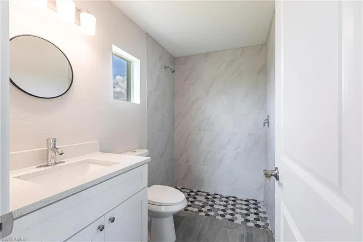 Bathroom with vanity and tiled shower