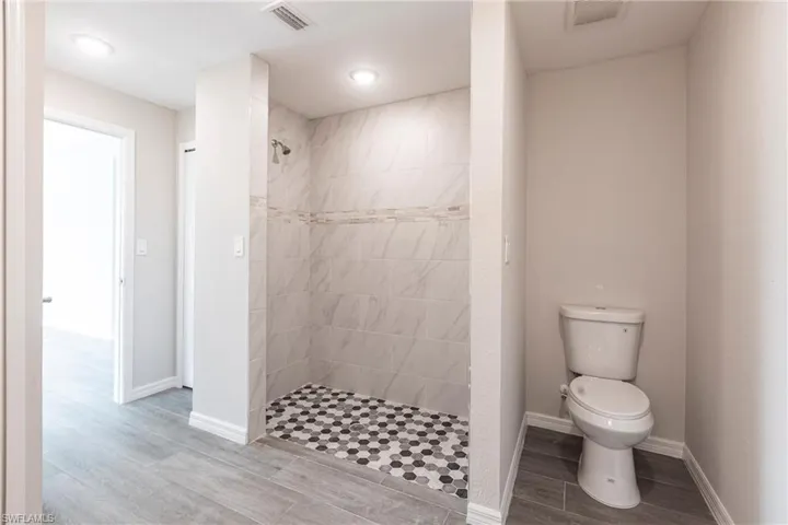 Full bathroom featuring a walk in shower and wood finished floors
