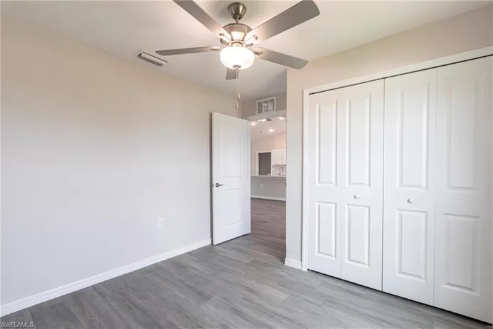 Unfurnished bedroom featuring a closet, wood finished floors, and ceiling fan