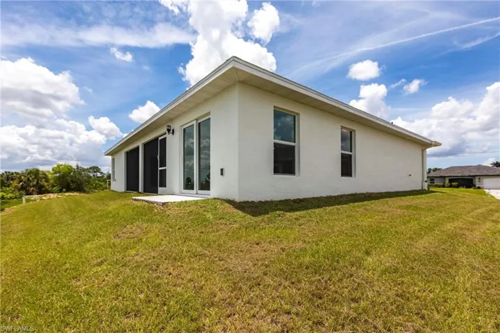 Back of property featuring stucco siding and a yard