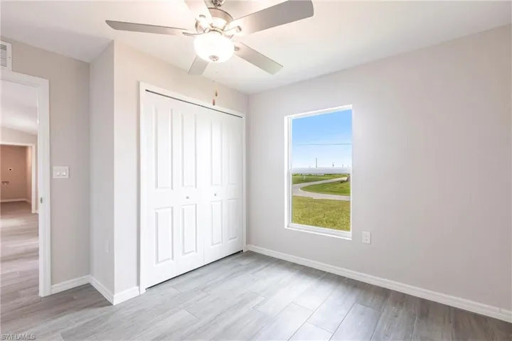 Unfurnished bedroom featuring a closet, light wood finished floors, and ceiling fan