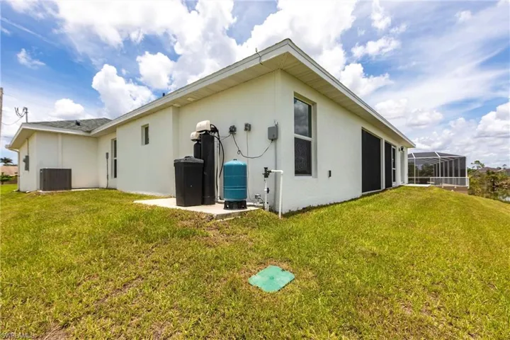 Rear view of property featuring stucco siding and a lawn