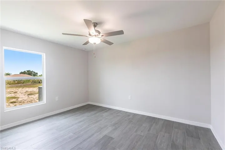 Unfurnished room with dark wood finished floors and a ceiling fan