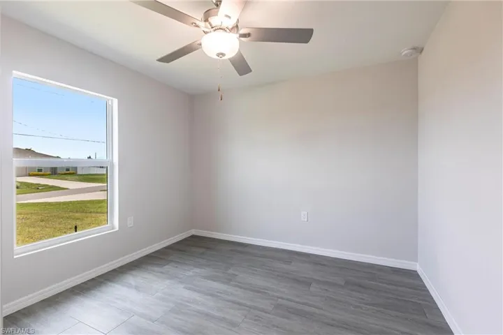 Unfurnished room with a ceiling fan and wood finished floors