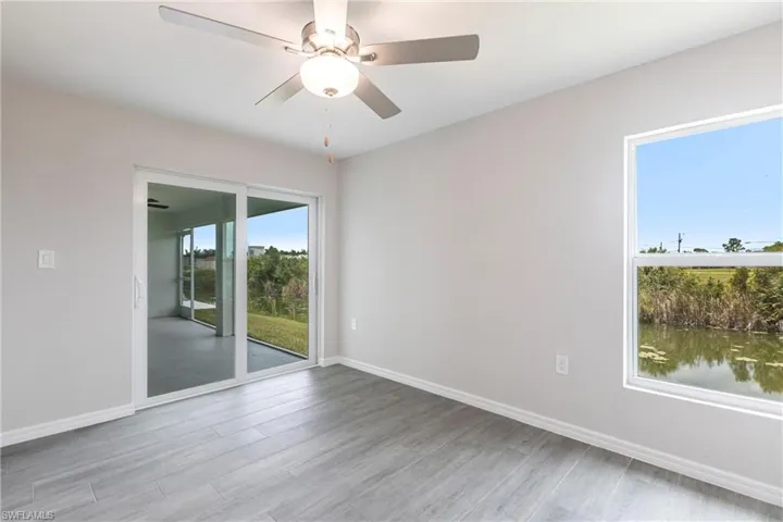 Empty room with wood finished floors and a ceiling fan