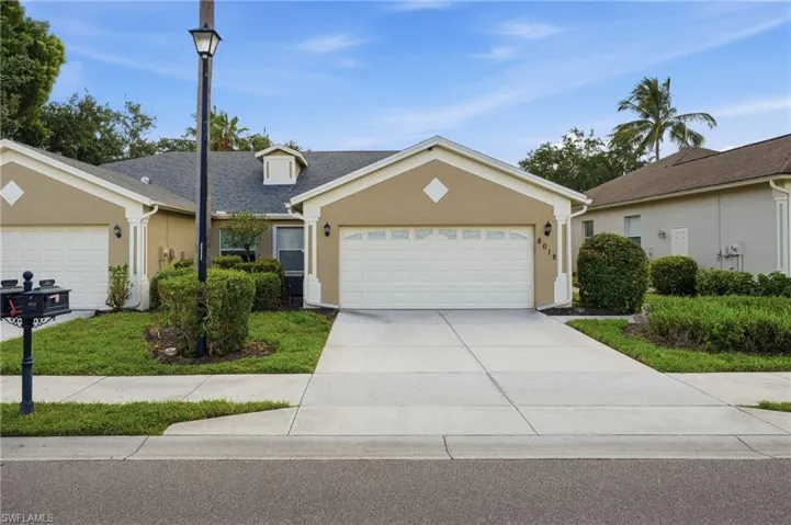 Single-story residence featuring a two-car garage with a panel door, a concrete driveway, and a shingled roof