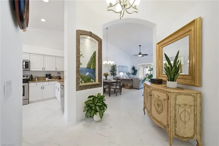 White tile flooring throughout the entryway and kitchen