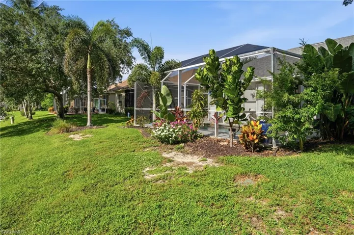Expansive green lawn with mature palm trees and diverse landscaping