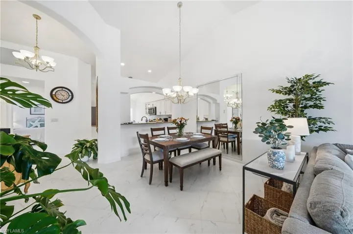 Open-concept interior featuring light-toned flooring and vaulted ceilings