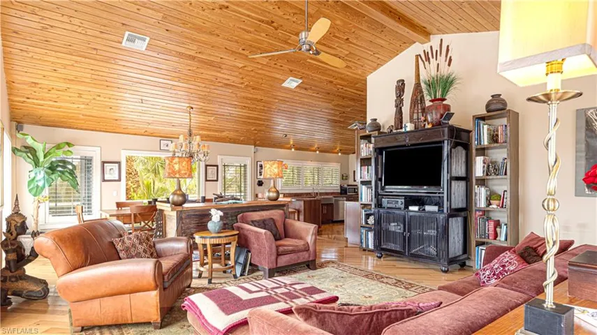 Living room with wood ceiling, high vaulted ceiling, light wood-type flooring, and a wealth of natural light