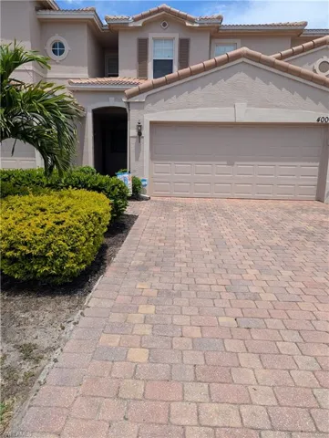 Mediterranean / spanish home with a tile roof, decorative driveway, and stucco siding