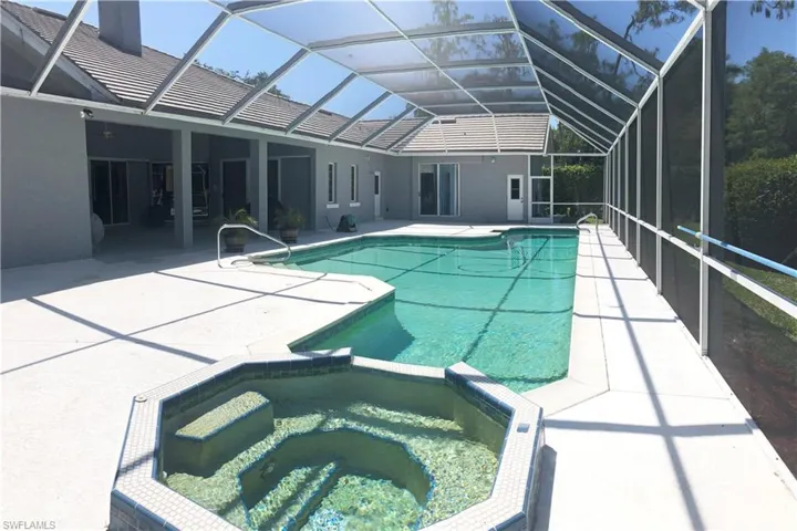 View of pool with a patio area, a pool with connected hot tub, and lap-lane.