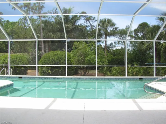 Swimming pool and screen enclosure with landscaped view