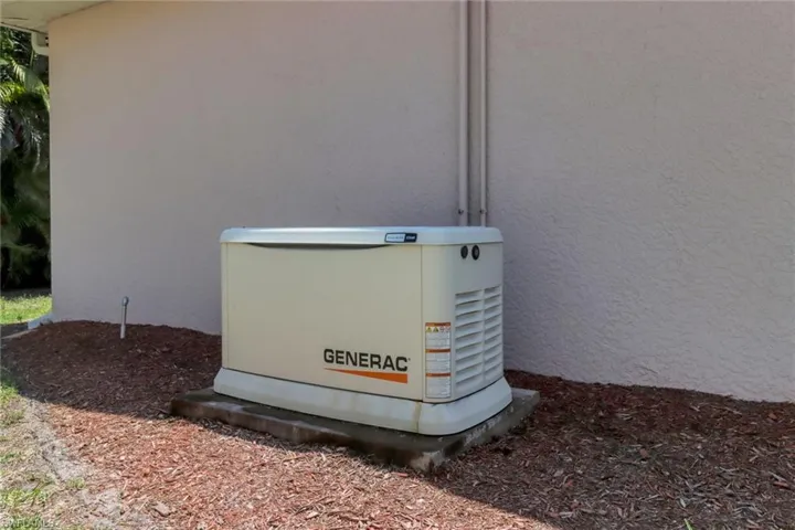 Exterior details featuring stucco siding and a power unit