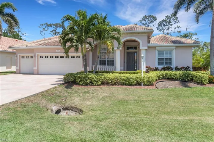 Mediterranean / spanish home with a tiled roof, driveway, a front lawn, and a garage