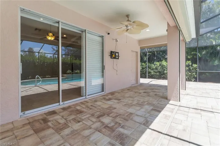 View of patio featuring glass enclosure and a ceiling fan