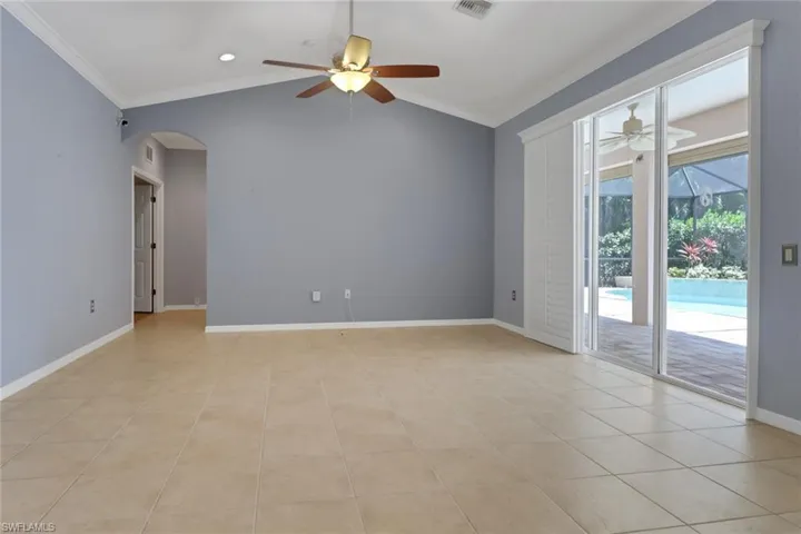 Spare room with arched walkways, ornamental molding, and ceiling fan