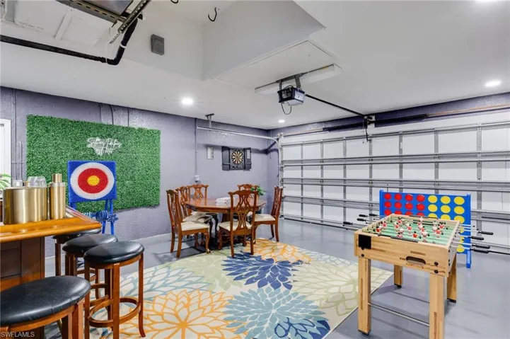 Finished garage space featuring a large floral area rug and recessed lighting