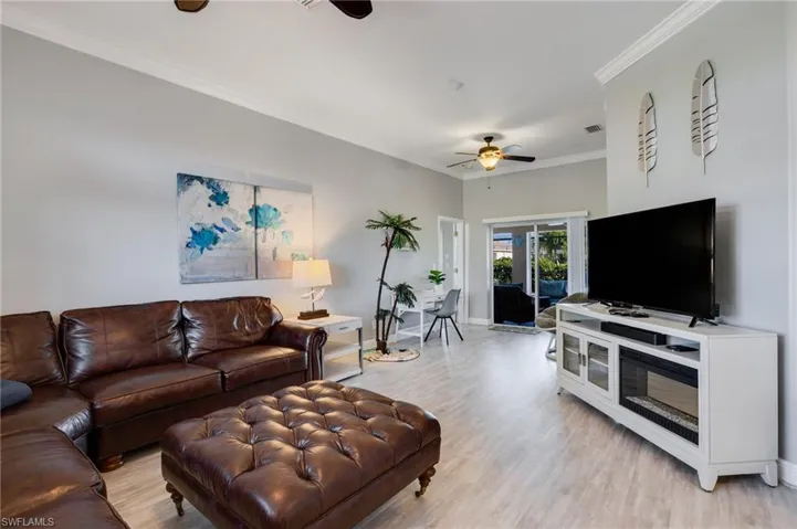 Spacious living area featuring wood-finish flooring, crown molding, and recessed lighting