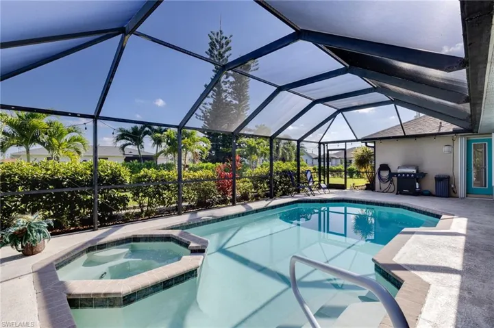 Screened lanai featuring a swimming pool and attached spa