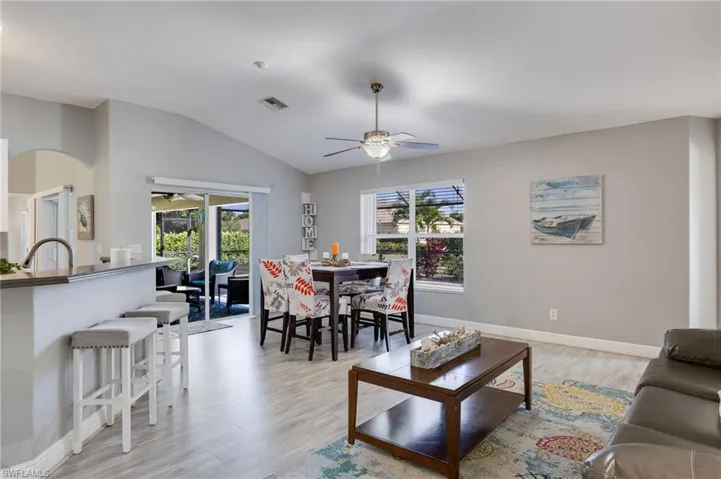Vaulted ceilings enhance this open-concept living space, featuring light wood-finish flooring throughout
