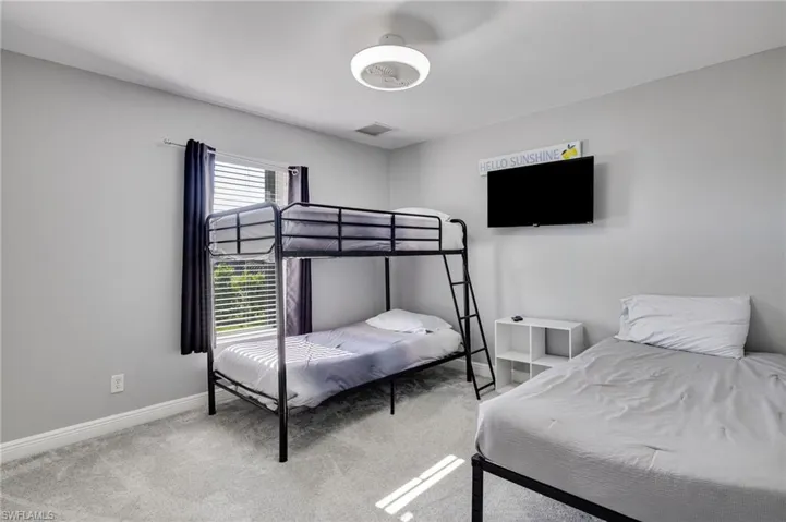 Carpeted room featuring a window with blinds and drapes, a flush-mount ceiling light fixture, and light gray wall paint