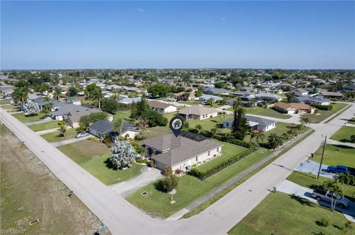 Single-story residence featuring a neutral-toned exterior, an attached garage, and a screened-in rear patio