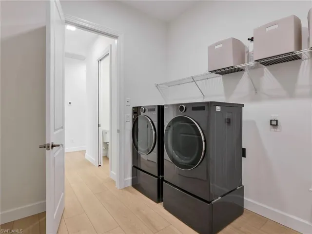 Laundry area with light wood-style floors and separate washer and dryer