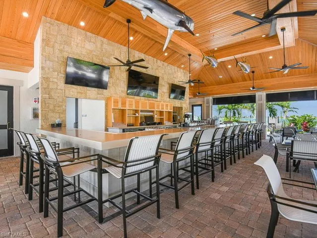 Kitchen featuring high vaulted ceiling, wood ceiling, recessed lighting, and a breakfast bar
