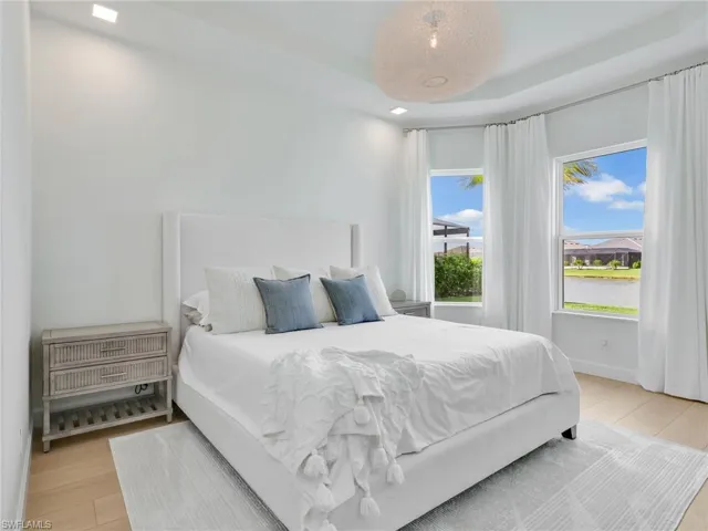 Bedroom featuring light wood finished floors and a tray ceiling