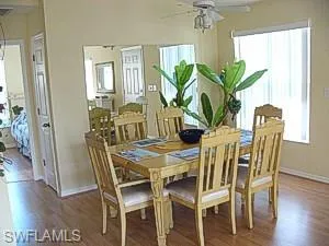 Dining room featuring dark hardwood / wood-style flooring, ceiling fan, and a healthy amount of sunlight