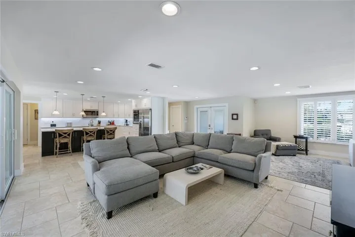 Living area with recessed lighting, stone tile flooring, and baseboards