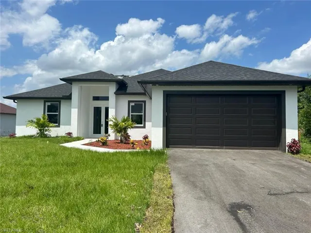 View of front of home with a garage and a front yard